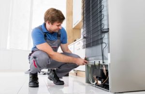 تکنیسین متخصص در حال تعمیر یخچال مدیا